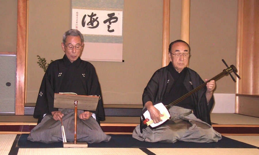 Sur la scène de côté: le lecteur et le joueur de shamisen